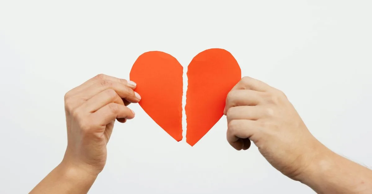Two hands holding the halves of a torn paper heart, representing divorce and child custody in Alabama